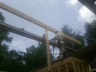 Carpenter setting a ridge beam over a new addition frame — Ice Dam Removal by Roofing Brothers in Dugway